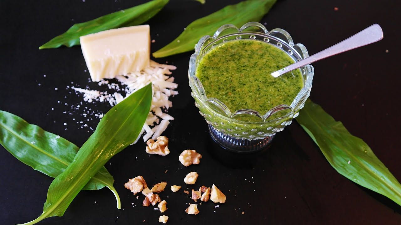 Salsa verde modenese in una ciotola bianca, densa e verde intenso, con gocce d'olio d'oliva, accanto a rametti di prezzemolo fresco e spicchi d'aglio